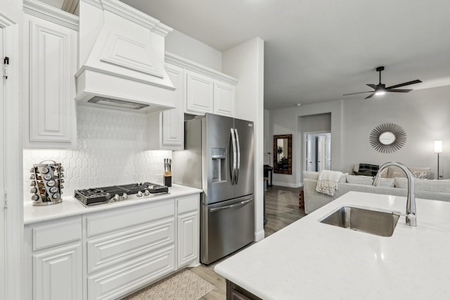 kitchen featuring appliances with stainless steel finishes, white cabinetry, and custom range hood