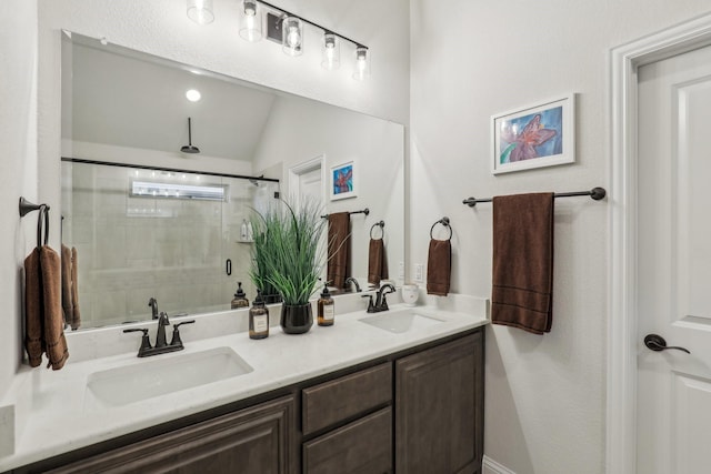 full bath with lofted ceiling, tiled shower, a sink, and double vanity