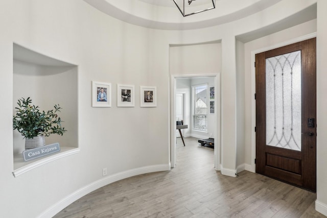 foyer with light wood finished floors and baseboards