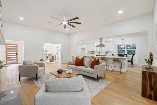 living room featuring ceiling fan and light hardwood / wood-style flooring