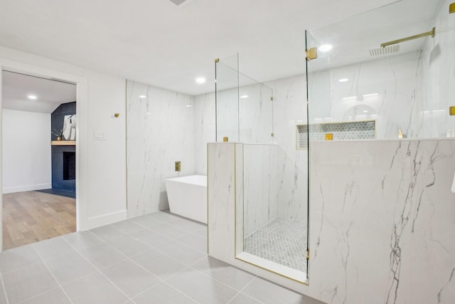 bathroom with tile patterned floors, shower with separate bathtub, and a fireplace