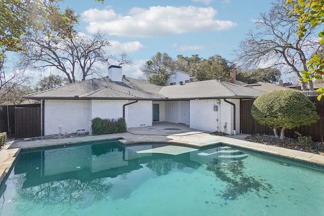 back of house with a fenced in pool and a patio area