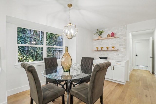 dining space featuring a healthy amount of sunlight, light wood-type flooring, and a chandelier