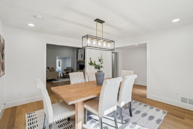 dining space with an inviting chandelier and light wood-type flooring