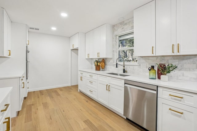 kitchen featuring sink, white cabinets, stainless steel dishwasher, and tasteful backsplash