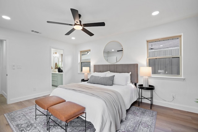 bedroom featuring ceiling fan, wood-type flooring, and ensuite bath