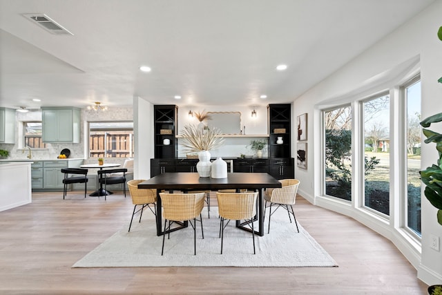 dining space featuring light wood-type flooring and sink