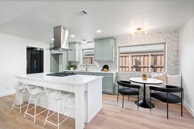 kitchen featuring sink, breakfast area, light hardwood / wood-style flooring, and island range hood