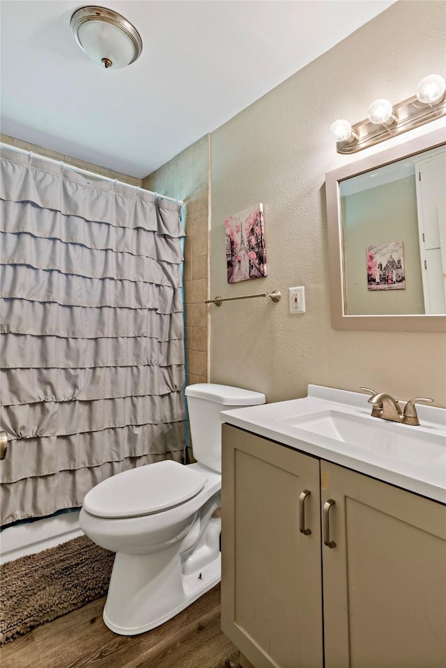 bathroom featuring toilet, vanity, and hardwood / wood-style flooring