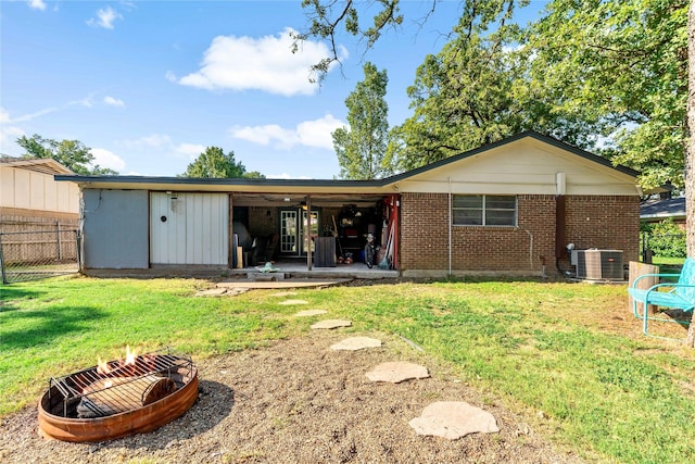 back of property with central air condition unit and a yard