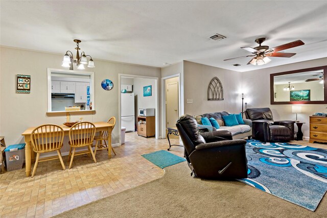 living room featuring ceiling fan with notable chandelier