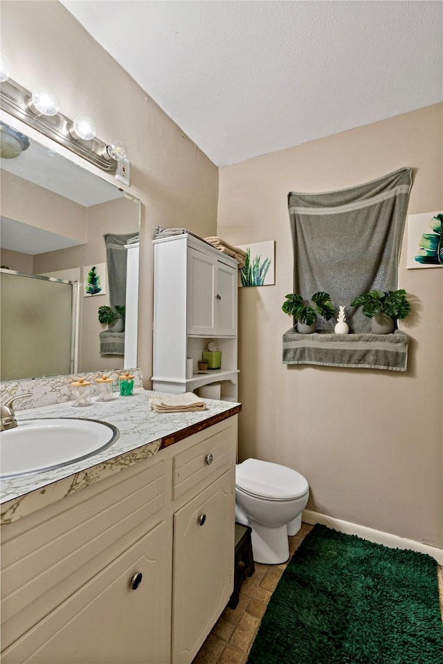 bathroom with toilet, a shower with door, and vanity