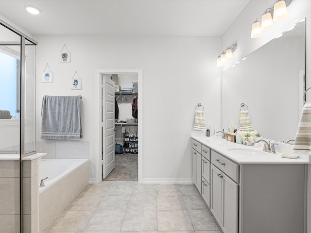 bathroom featuring vanity, tile patterned floors, and tiled tub