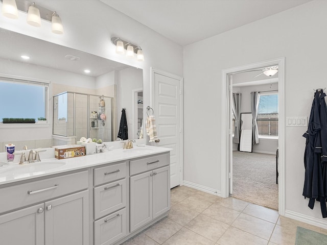 bathroom featuring ceiling fan, tile patterned flooring, a shower with shower door, and vanity