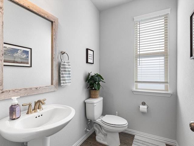 bathroom with toilet, hardwood / wood-style flooring, and sink