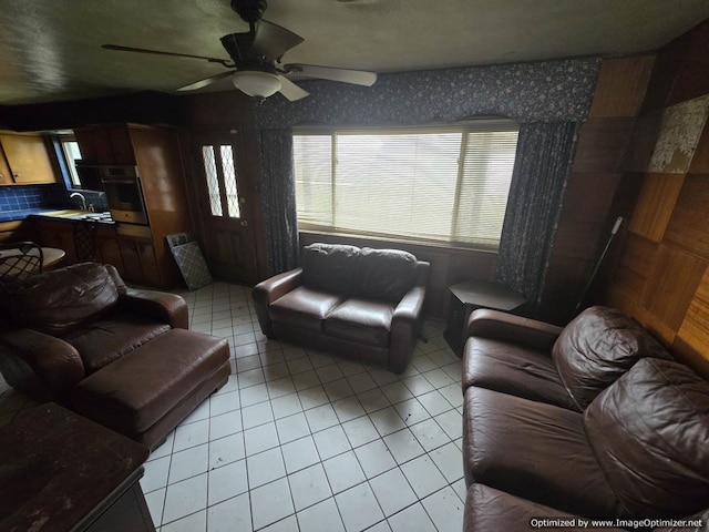 tiled living room with ceiling fan and sink