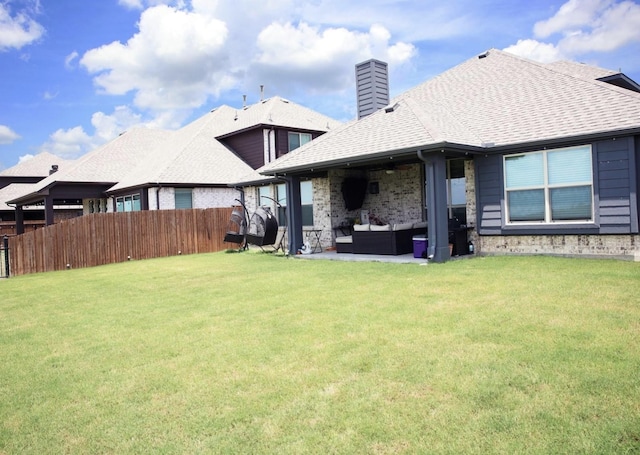 back of property with an outdoor living space and a lawn