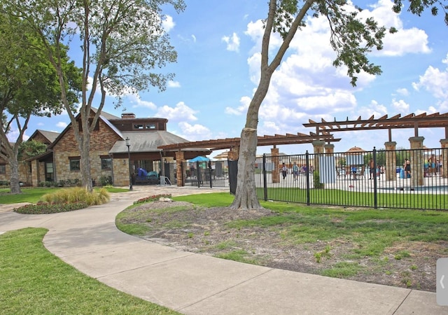 view of home's community featuring a pergola and a lawn