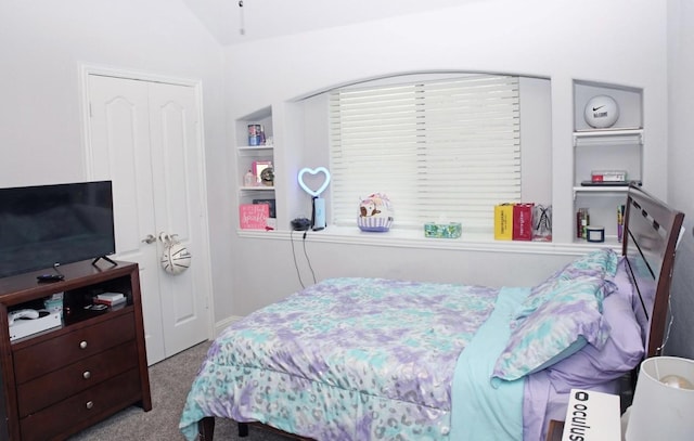 bedroom featuring light colored carpet, vaulted ceiling, and a closet