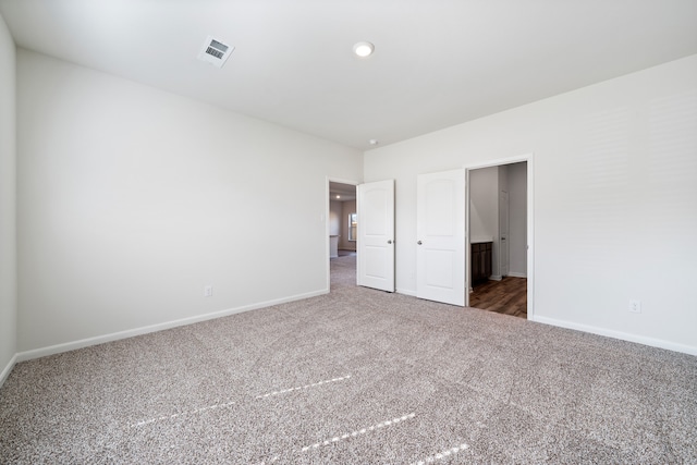 unfurnished bedroom with dark carpet