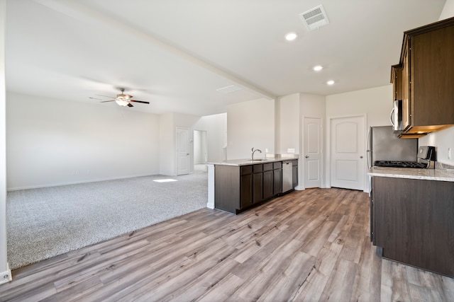 kitchen featuring light hardwood / wood-style floors, ceiling fan, dark brown cabinets, range, and sink