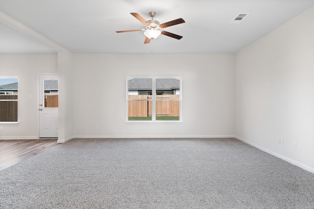 spare room with ceiling fan, carpet flooring, and plenty of natural light