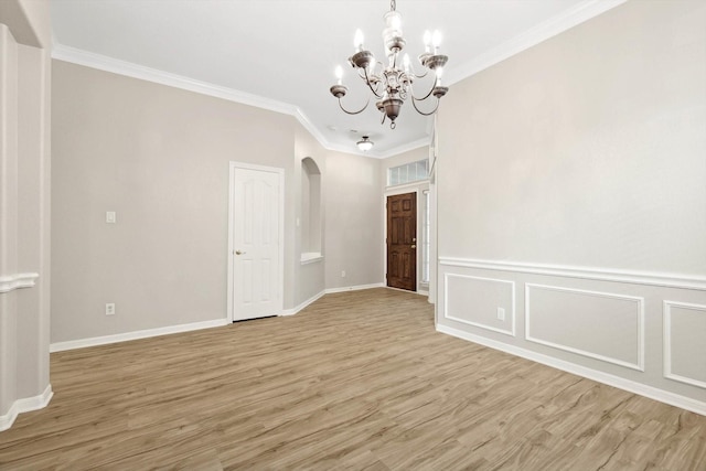 unfurnished room featuring crown molding, a notable chandelier, and light wood-type flooring