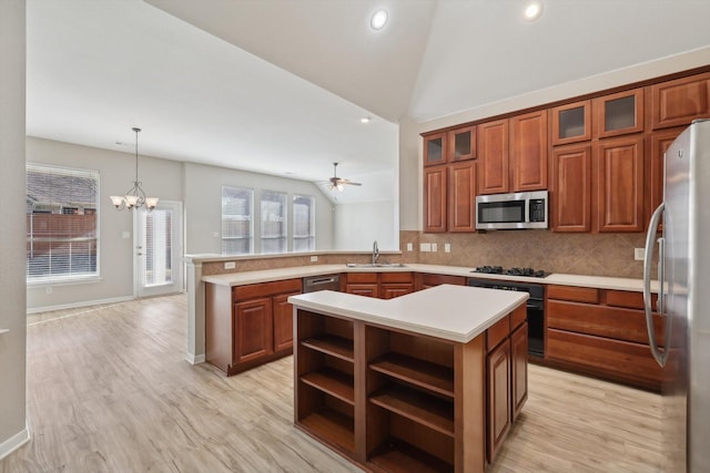 kitchen featuring hanging light fixtures, appliances with stainless steel finishes, kitchen peninsula, and lofted ceiling