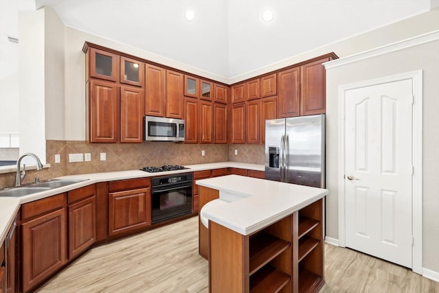 kitchen with black appliances, a kitchen island, tasteful backsplash, sink, and light wood-type flooring