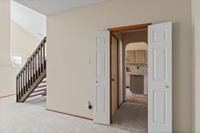 staircase featuring carpet floors and lofted ceiling