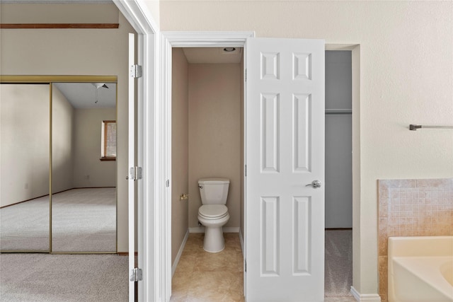 bathroom featuring a tub to relax in and toilet