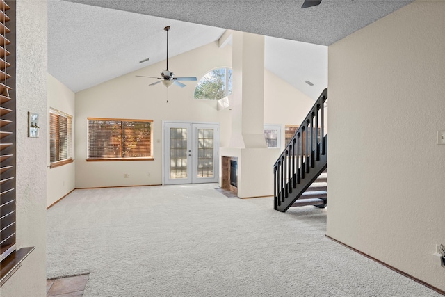 living room with a textured ceiling, french doors, high vaulted ceiling, ceiling fan, and light colored carpet