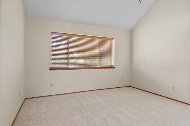 unfurnished room with light carpet and vaulted ceiling