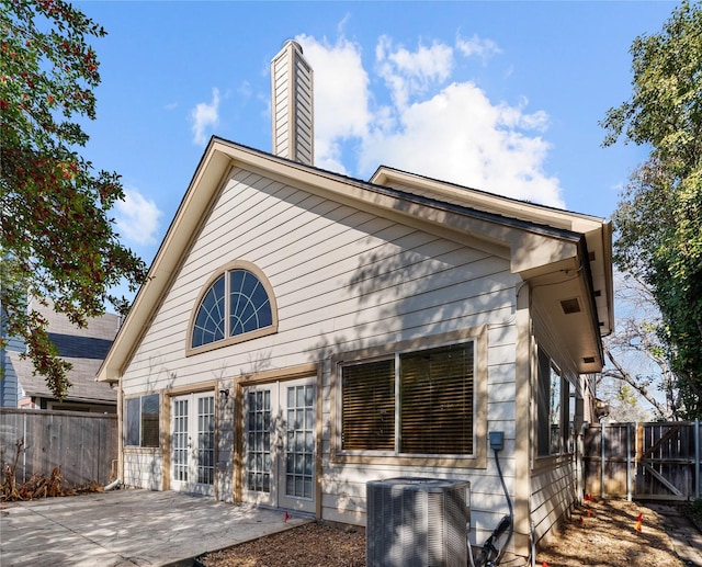 rear view of house featuring a patio area, cooling unit, and french doors