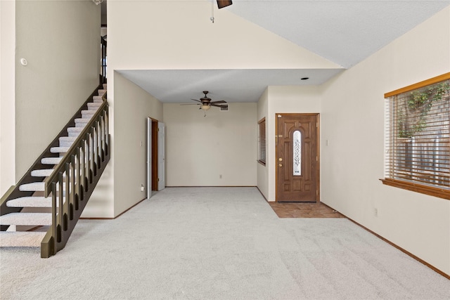 carpeted entryway featuring lofted ceiling and ceiling fan