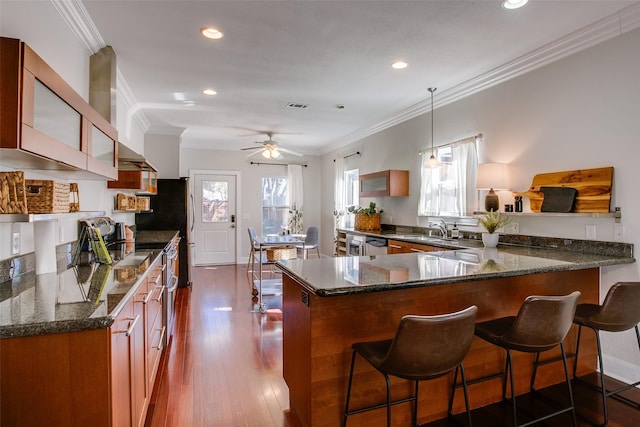 kitchen with sink, hanging light fixtures, dark hardwood / wood-style floors, kitchen peninsula, and crown molding