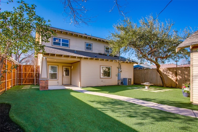 back of house featuring central AC unit, a patio area, and a lawn