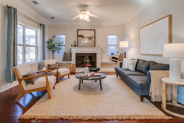 living room with ceiling fan, dark hardwood / wood-style flooring, crown molding, and a premium fireplace