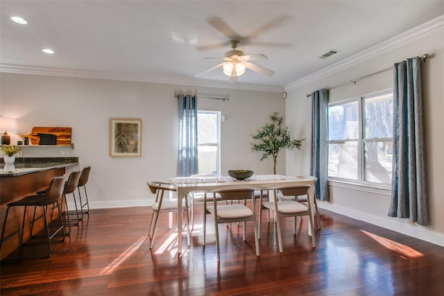 dining area featuring ceiling fan, dark hardwood / wood-style floors, a wealth of natural light, and crown molding