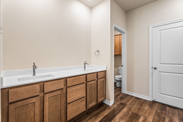 bathroom with toilet, vanity, and hardwood / wood-style flooring