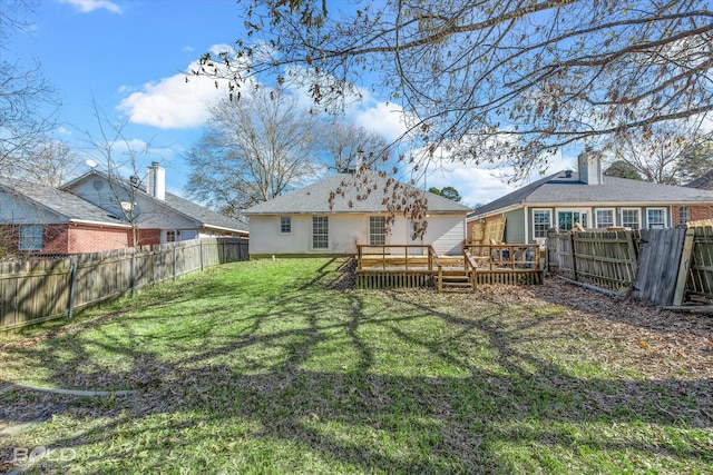 back of property with a wooden deck and a yard