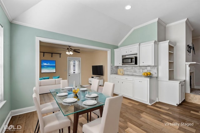 dining room featuring crown molding, ceiling fan, vaulted ceiling, and light wood-type flooring