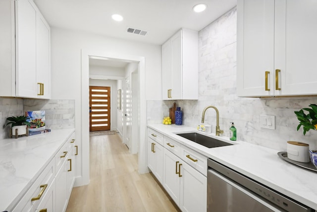 kitchen featuring white cabinetry, light hardwood / wood-style floors, sink, light stone counters, and stainless steel dishwasher