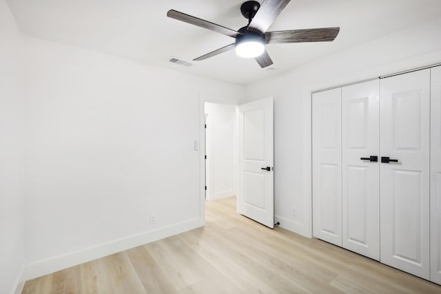 unfurnished bedroom featuring ceiling fan, light hardwood / wood-style floors, and a closet