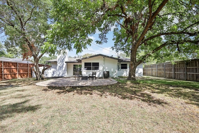 back of property featuring a lawn and a patio