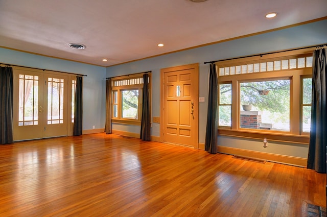 interior space featuring light hardwood / wood-style flooring, ornamental molding, and french doors