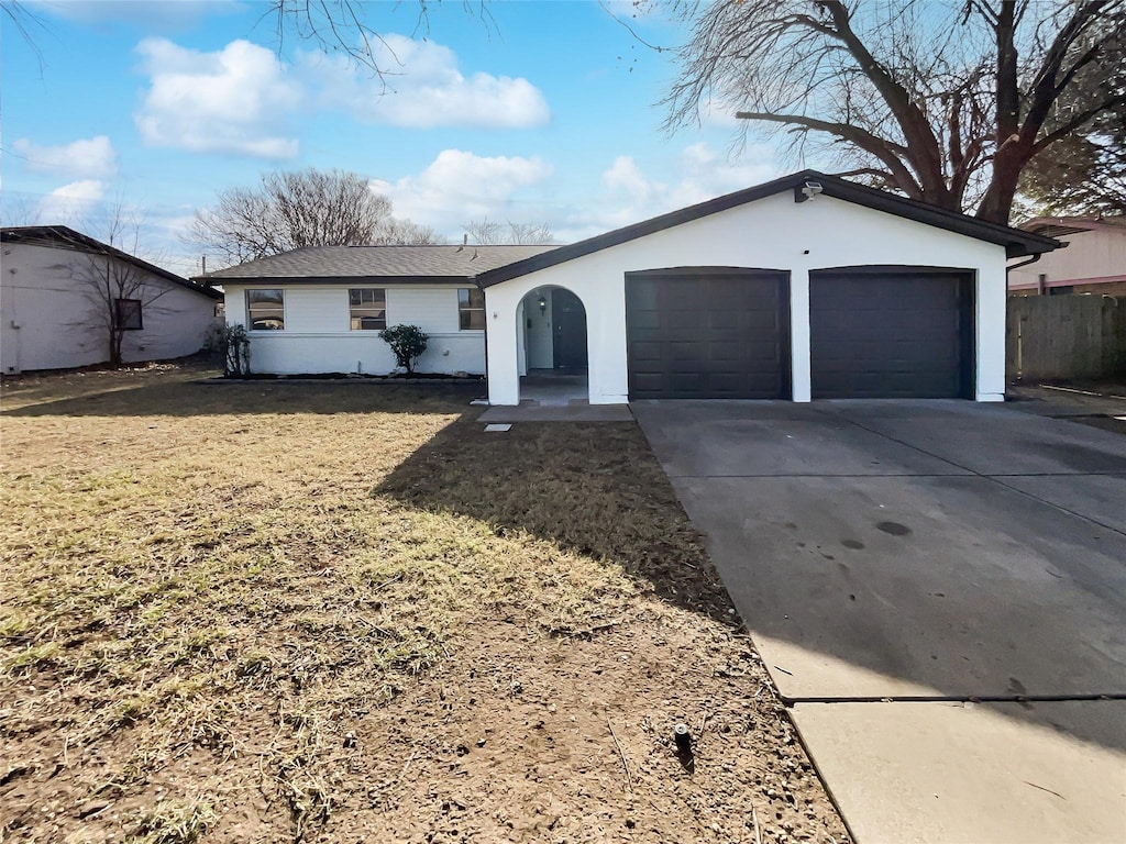 ranch-style house featuring a garage and a front lawn