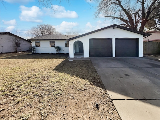 ranch-style house featuring a garage and a front lawn