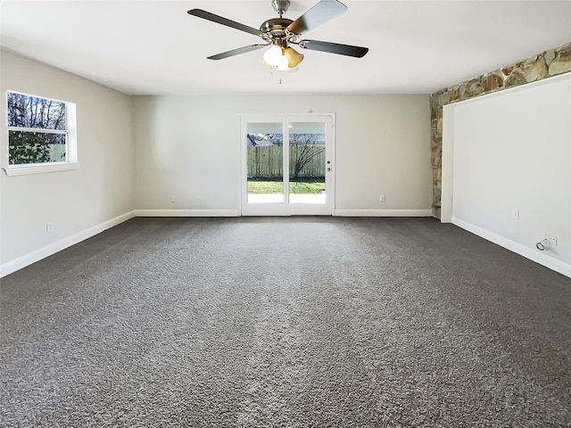 spare room with ceiling fan and dark carpet