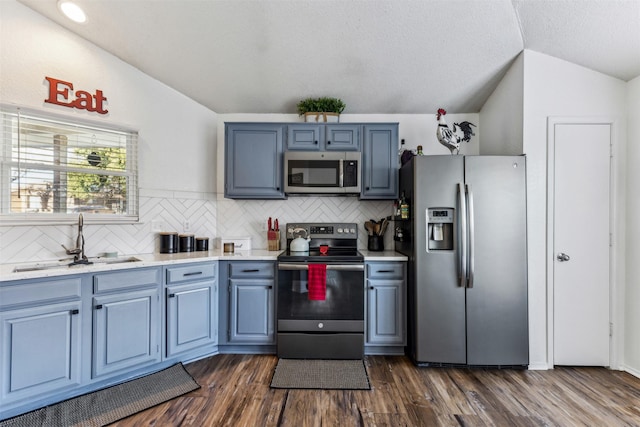 kitchen with lofted ceiling, sink, tasteful backsplash, and stainless steel appliances